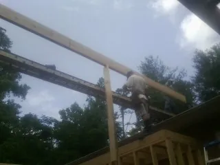 Carpenter setting a ridge beam over a new addition frame — Ice Dam Removal by Roofing Brothers in Liberty Mills