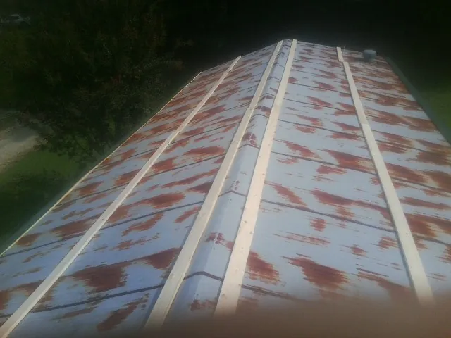 Rusted metal roof panels with new wood purlins before replacement — Storm Damage Roof Repair in Liberty Mills by Roofing Brothers