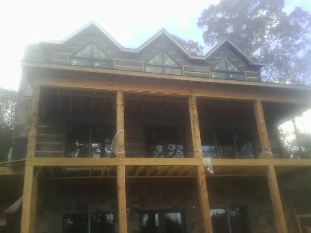 Dormers and porch framing on a large log home under construction in Liberty Mills