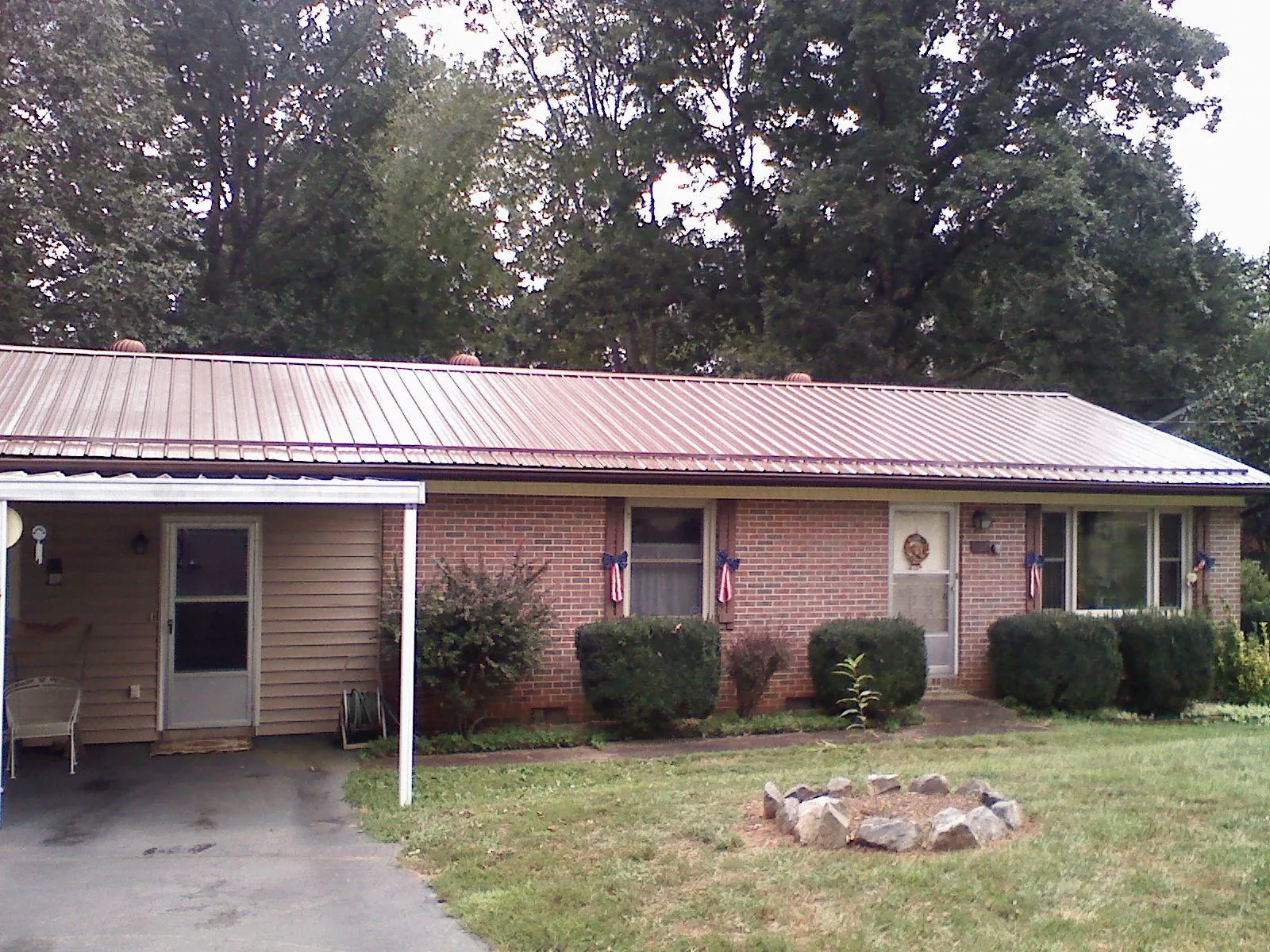 Bronze metal roof and carport on a brick ranch home — Roof Repair work by our crew in Liberty Mills